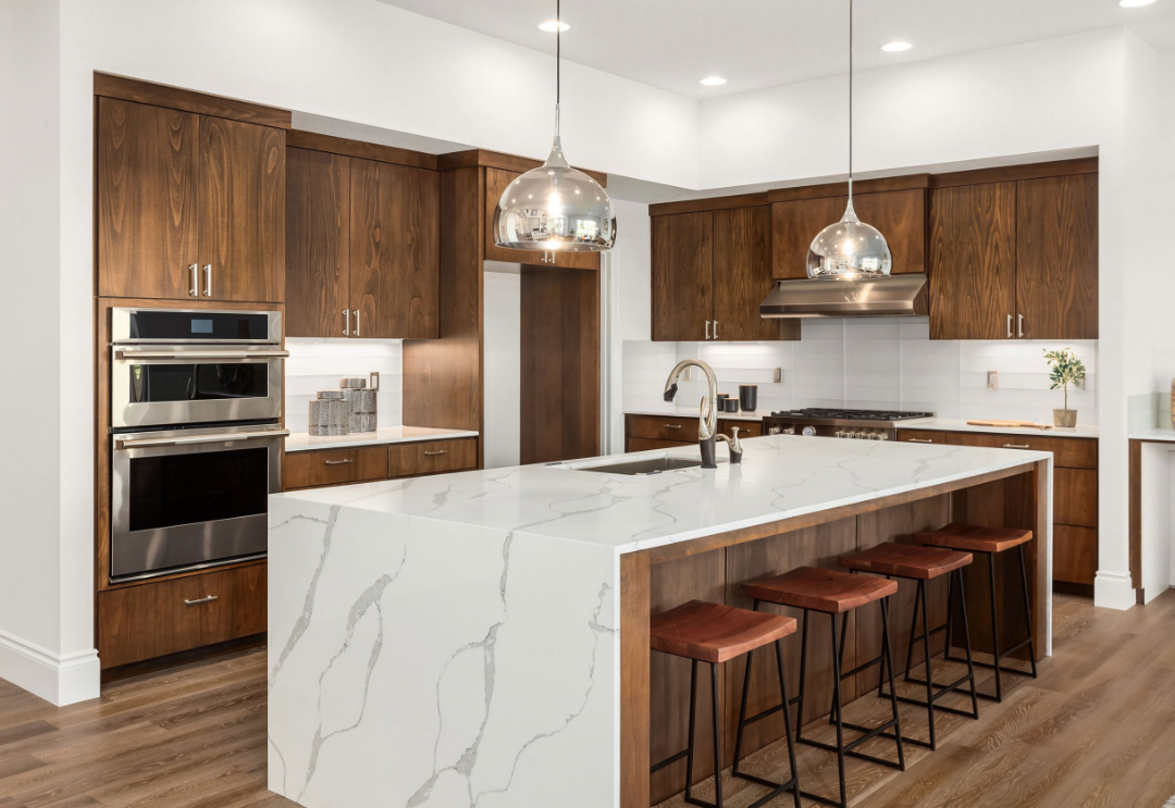 Kitchen island with brown wood cabinets and white countertops